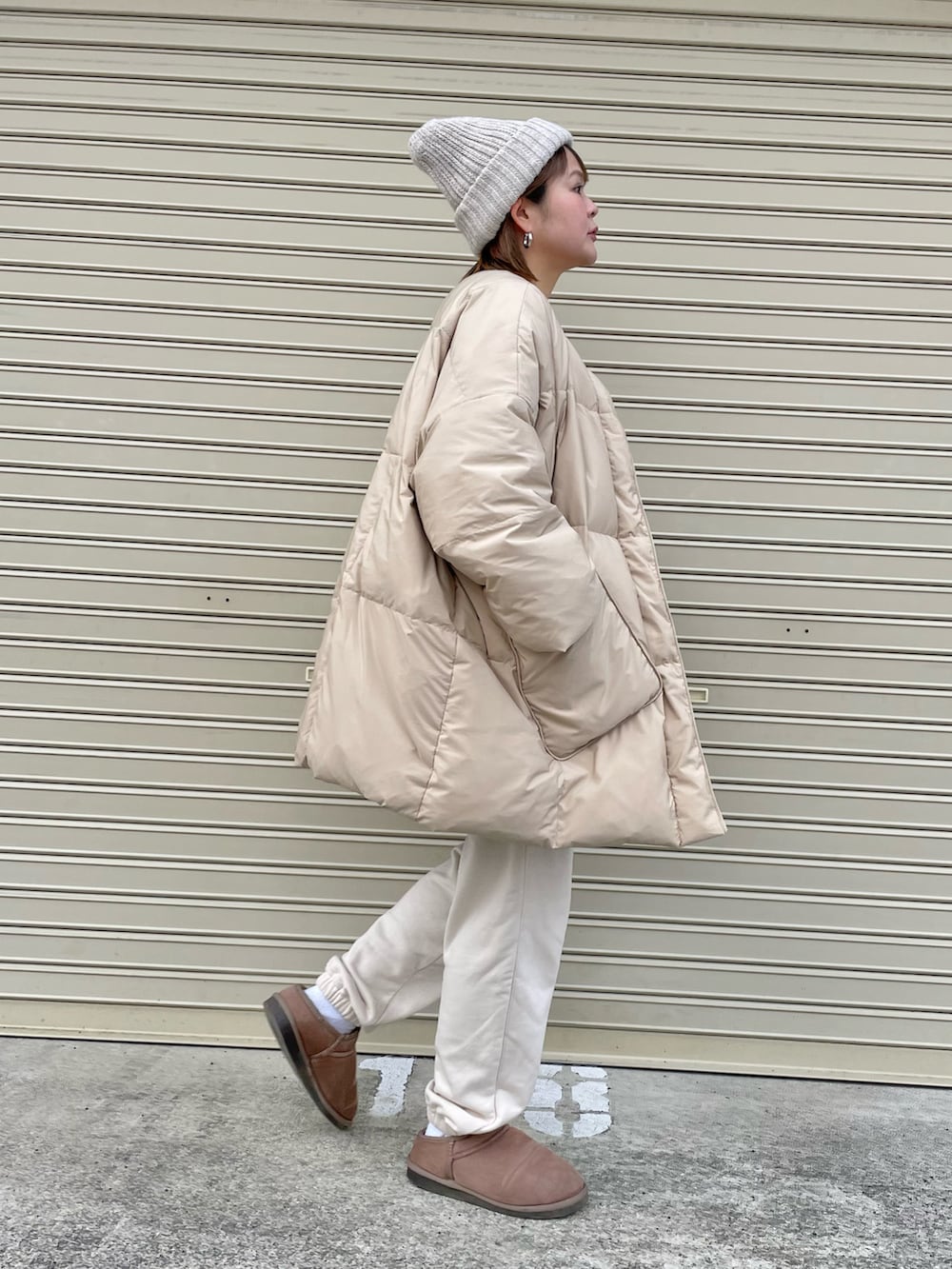 ベージュ系のダウンジャケット/コート、パープル系のニット/セーター、ホワイト系のニットキャップ/ビーニーを着用したレディースの冬コーディネートの3枚目の写真