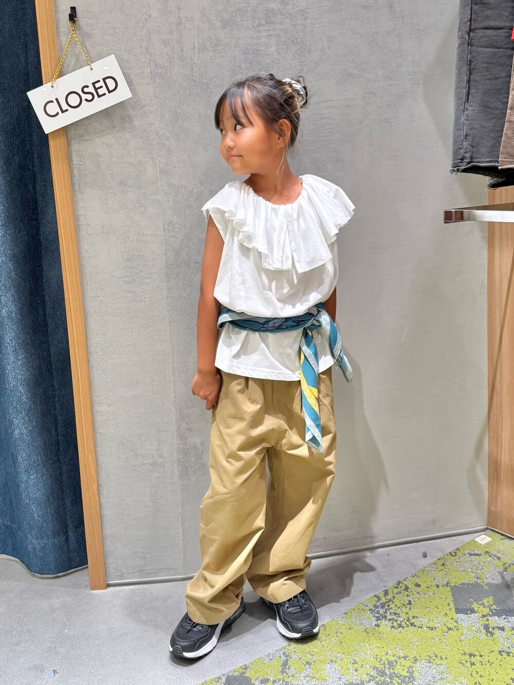 ベージュ系のその他パンツ、ホワイト系のTシャツ/カットソー、グリーン系のバンダナ/スカーフを着用したキッズの秋コーディネートの2枚目の写真