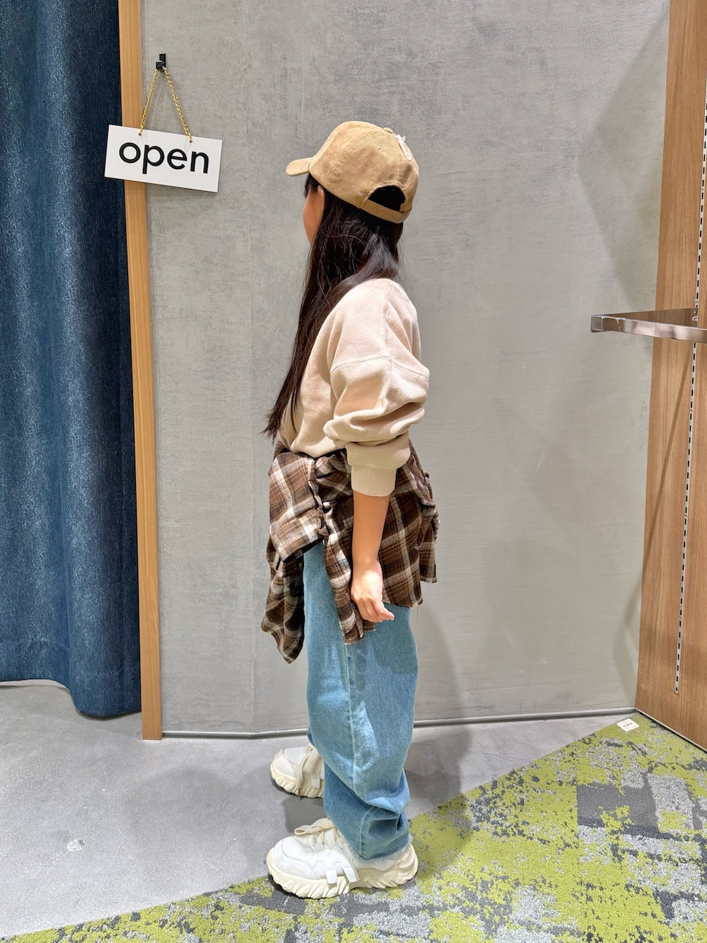 ベージュ系のニット/セーター、ブラウン系のシャツ/ブラウス、ブルー系のデニムパンツを着用したキッズの秋コーディネートの2枚目の写真