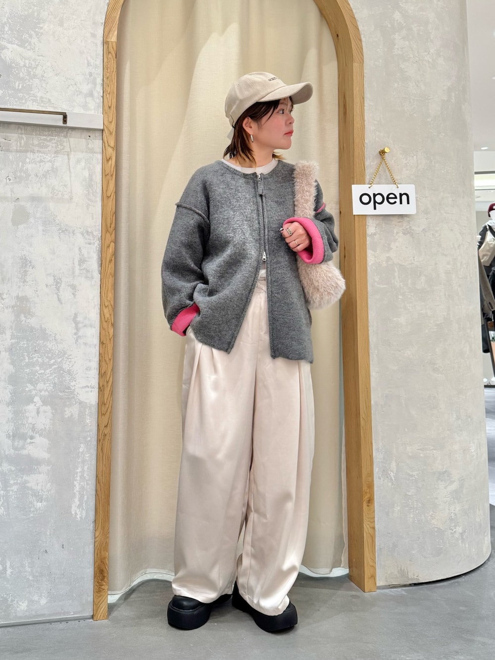 グレー系のカーディガン/ボレロ、ホワイト系のその他パンツ、ホワイト系のトートバッグを着用したレディースの秋コーディネートの2枚目の写真