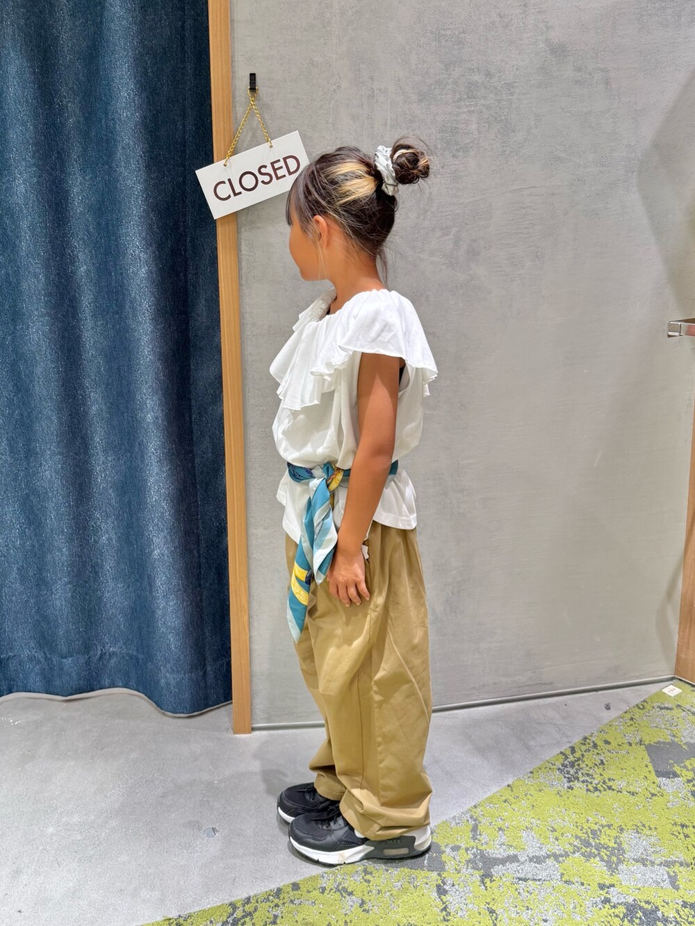 ベージュ系のその他パンツ、ホワイト系のTシャツ/カットソー、グリーン系のバンダナ/スカーフを着用したキッズの秋コーディネートの4枚目の写真