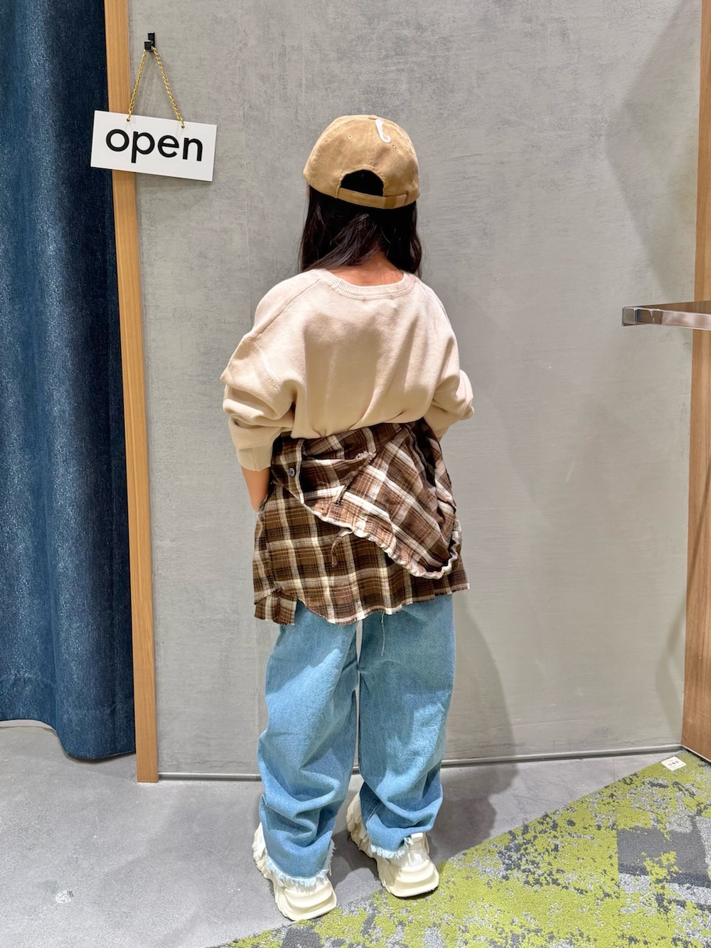 ベージュ系のニット/セーター、ブラウン系のシャツ/ブラウス、ブルー系のデニムパンツを着用したキッズの秋コーディネートの3枚目の写真