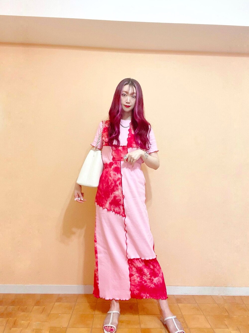 レッド系のスカート、レッド系のTシャツ/カットソー、ホワイト系のショルダーバッグを着用したレディースの春コーディネートの2枚目の写真