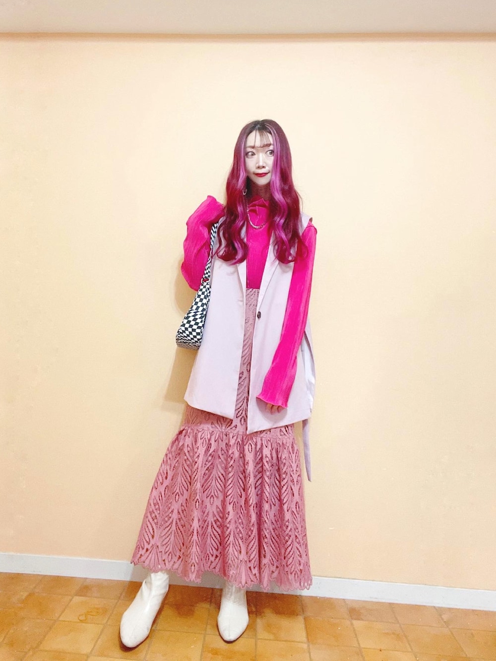 ピンク系のベスト、ピンク系のTシャツ/カットソー、ピンク系のスカートを着用したレディースの春コーディネートの2枚目の写真