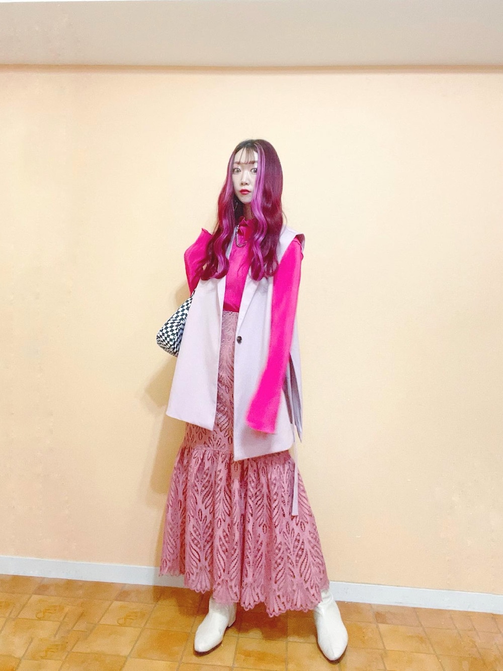 ピンク系のベスト、ピンク系のTシャツ/カットソー、ピンク系のスカートを着用したレディースの春コーディネートの3枚目の写真