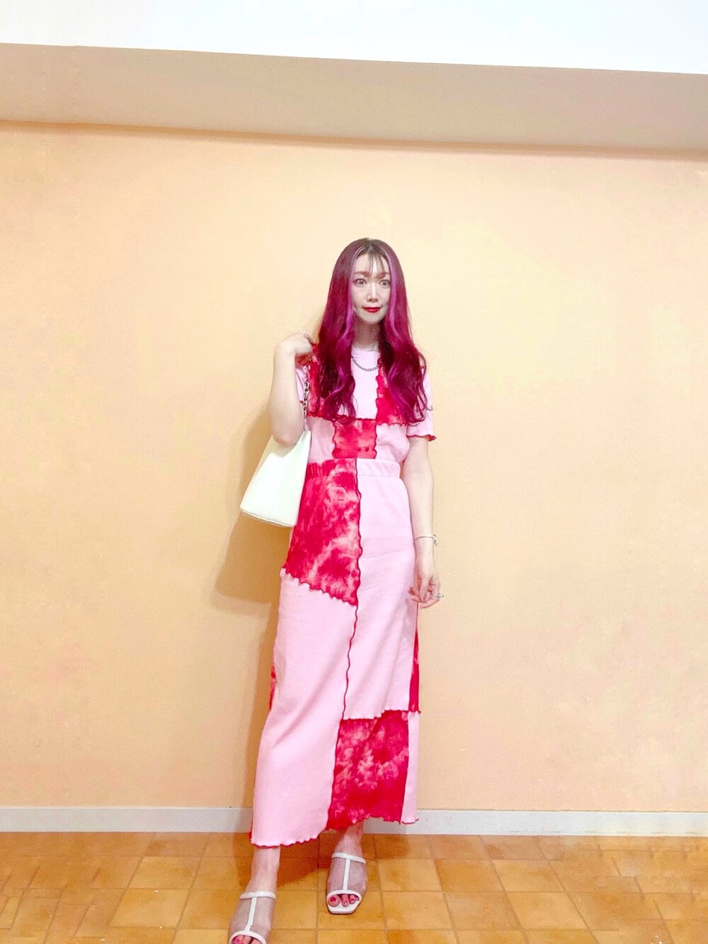 レッド系のスカート、レッド系のTシャツ/カットソー、ホワイト系のショルダーバッグを着用したレディースの春コーディネートの3枚目の写真