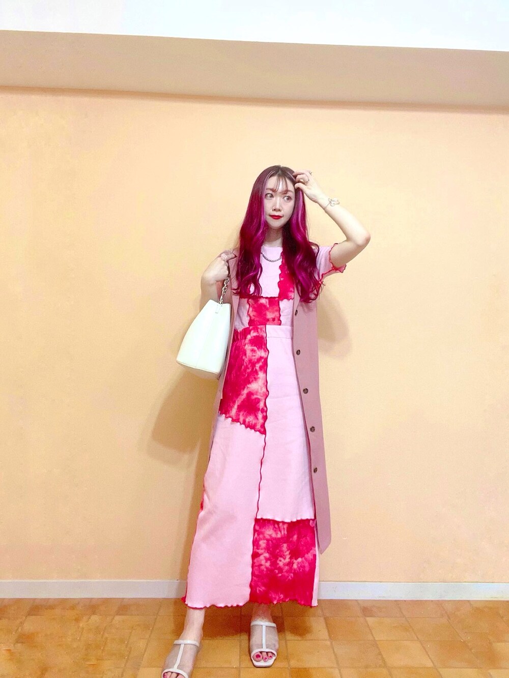 レッド系のスカート、レッド系のTシャツ/カットソー、ホワイト系のショルダーバッグを着用したレディースの春コーディネートの4枚目の写真