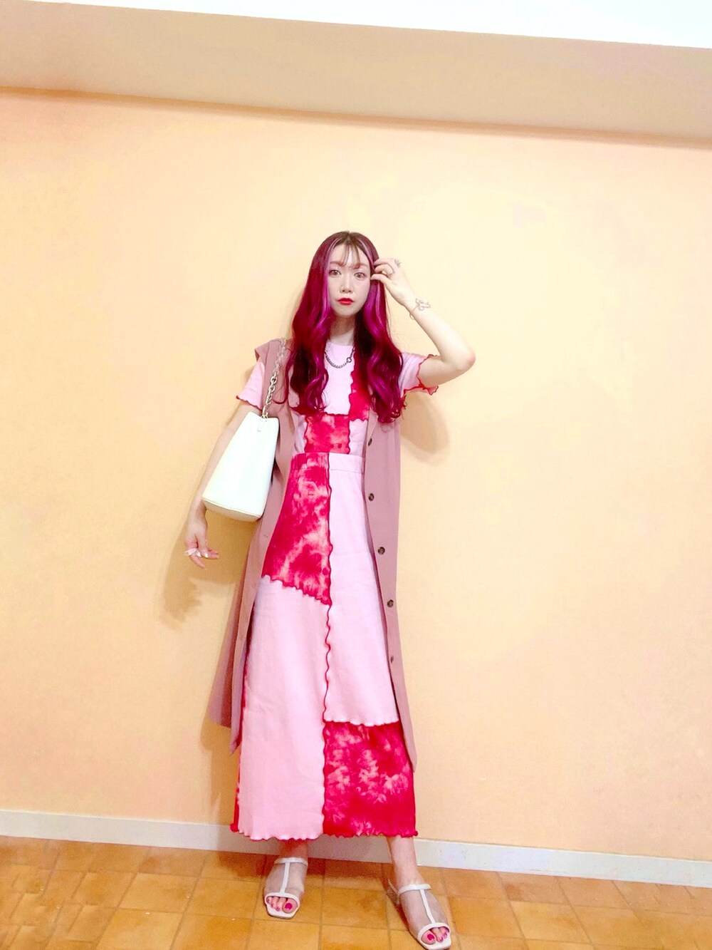 レッド系のスカート、レッド系のTシャツ/カットソー、ホワイト系のショルダーバッグを着用したレディースの春コーディネートの5枚目の写真