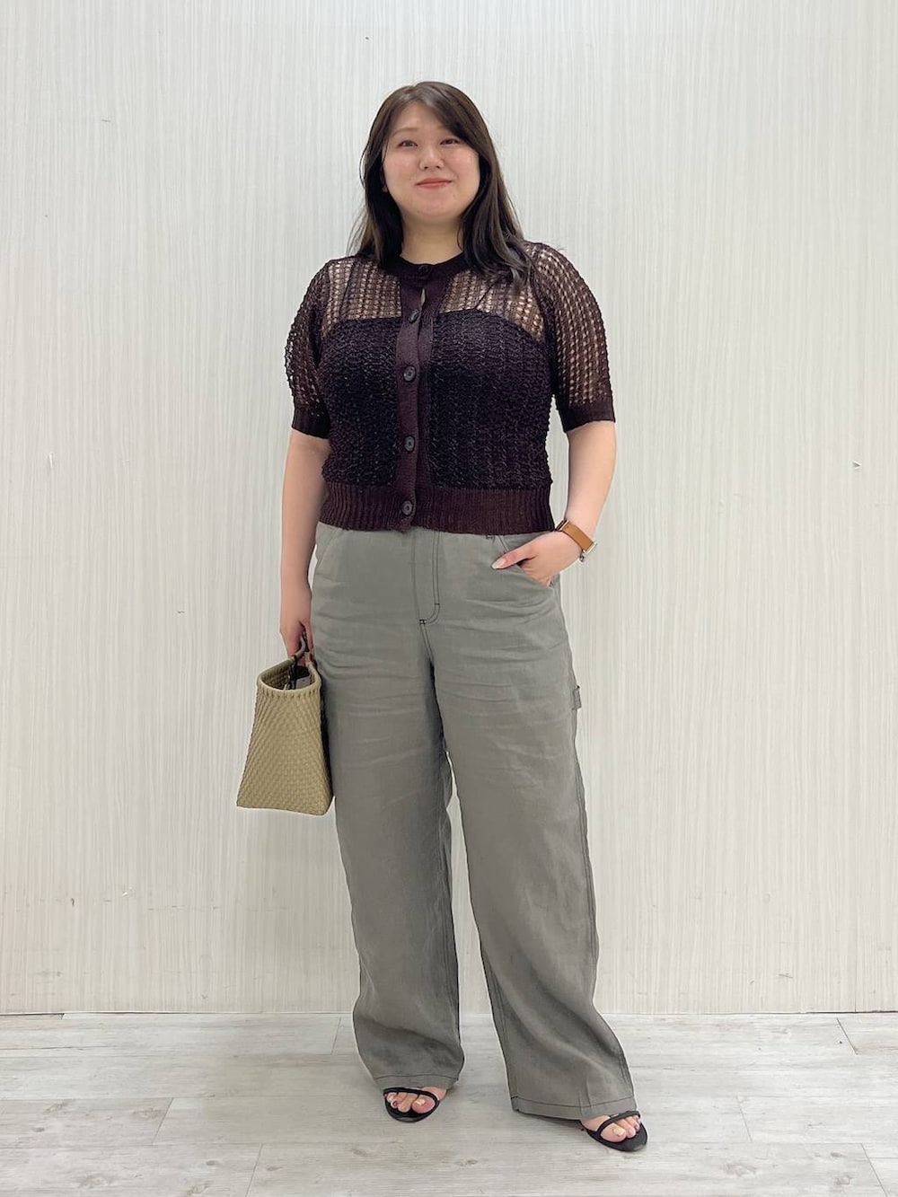 グレー系のその他パンツ、ベージュ系のハンドバッグ、ブラウン系のニット/セーターを着用したレディースの夏コーディネートの3枚目の写真