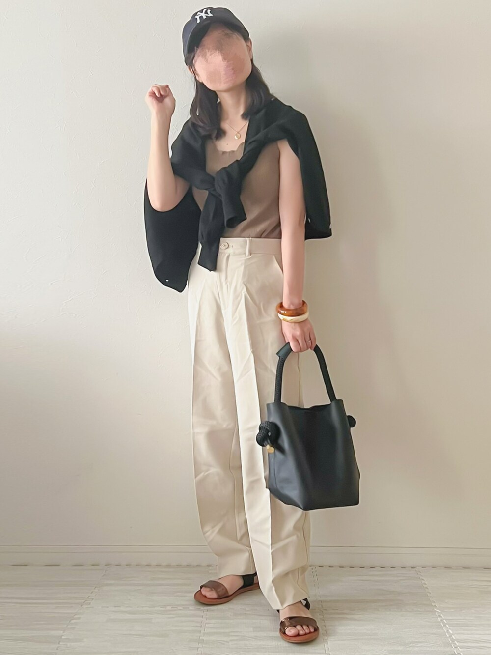 ブラウン系のタンクトップ、ホワイト系のその他パンツ、ブラック系のハンドバッグを着用したレディースの夏コーディネートの2枚目の写真