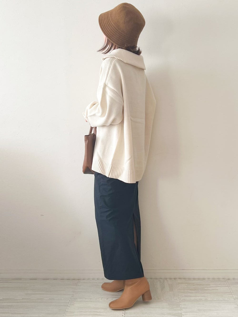 ホワイト系のニット/セーター、ブラウン系のショルダーバッグ、ブラック系のスカートを着用したレディースの秋コーディネートの3枚目の写真