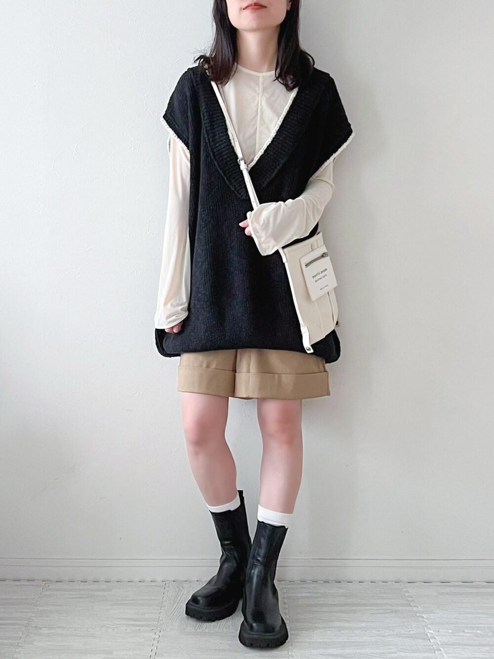 ブラック系のベスト、ブラック系のブーツ、ブラック系のボストンバッグを着用したレディースの秋コーディネートの4枚目の写真