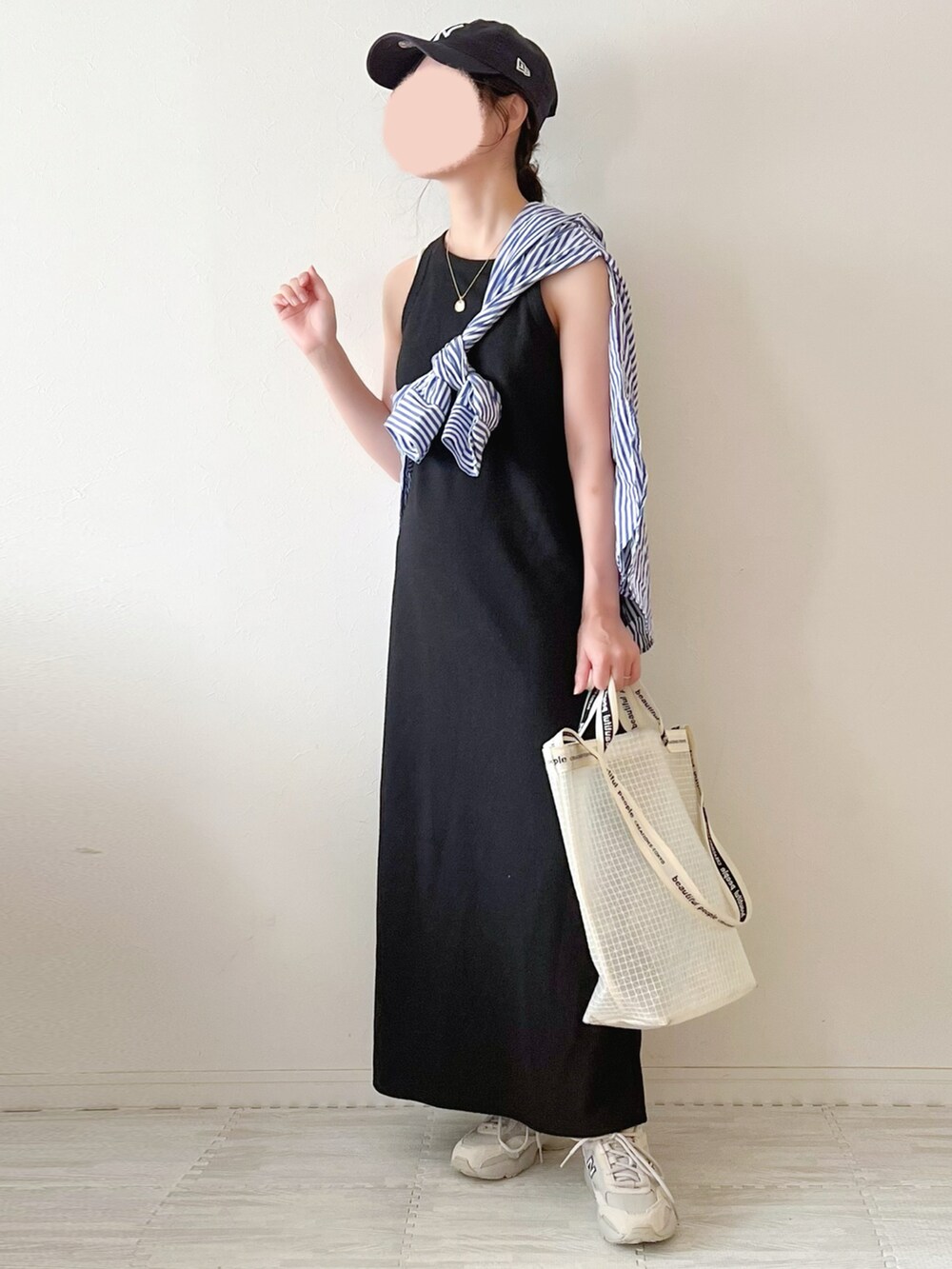 ベージュ系のスニーカー、ホワイト系のショルダーバッグ、ブラック系のワンピースを着用したレディースの夏コーディネートの2枚目の写真