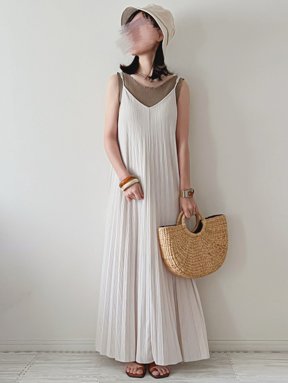 ホワイト系のワンピース、ブラウン系のタンクトップ、ベージュ系のかごバッグを着用したレディースの夏コーディネートの2枚目の写真