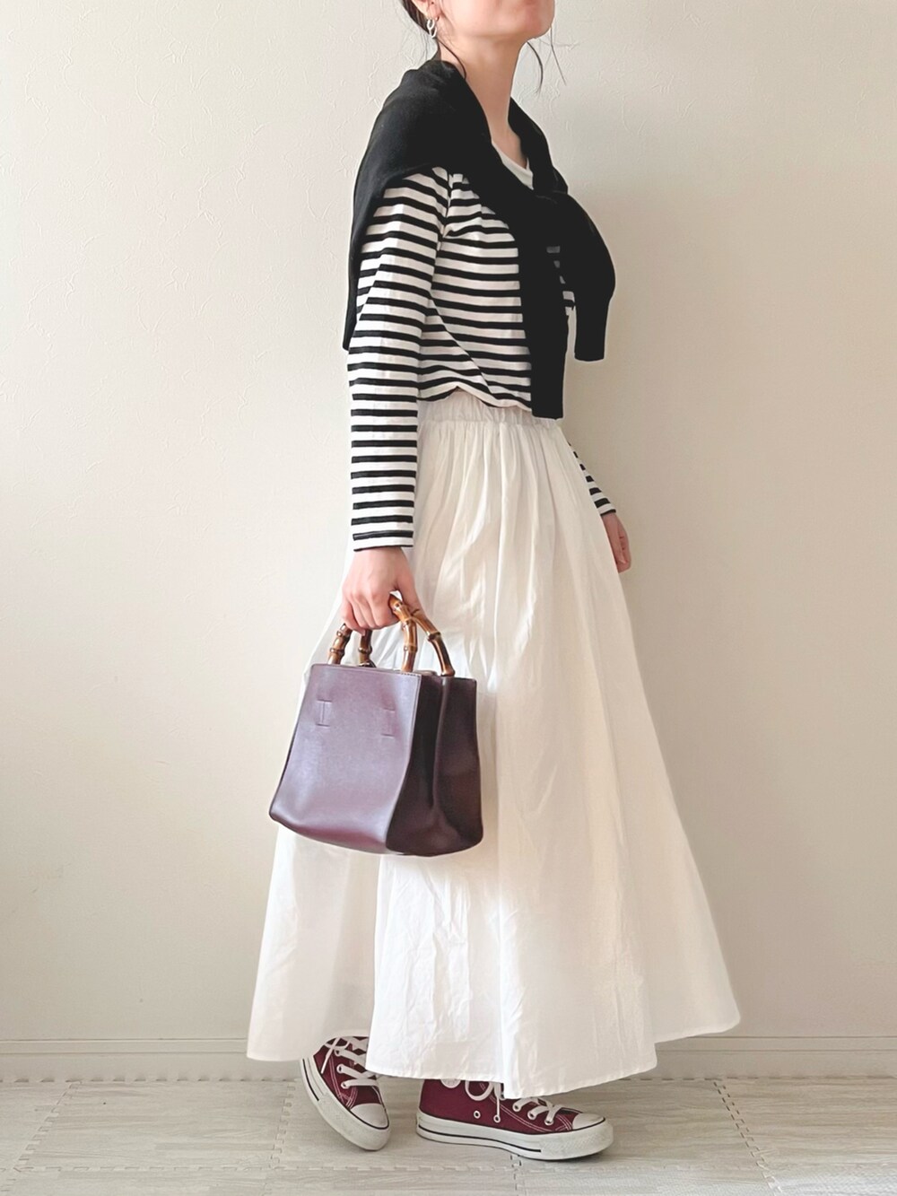 ホワイト系のスカート、パープル系のハンドバッグ、レッド系のスニーカーを着用したレディースの春コーディネートの2枚目の写真