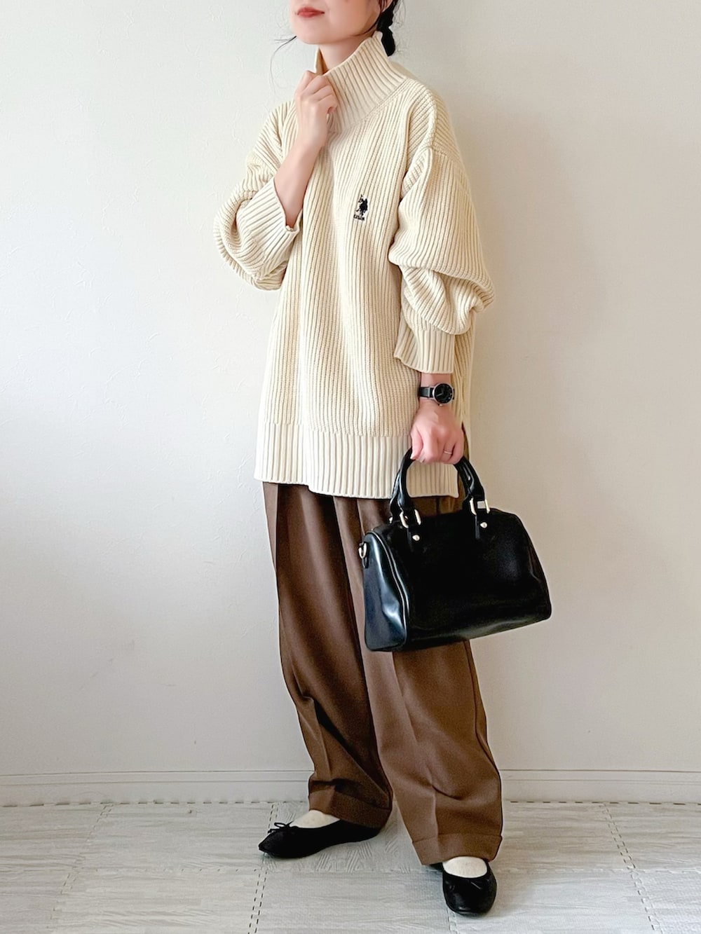 ホワイト系のニット/セーター、ブラック系のボストンバッグ、ブラウン系のパンツを着用したレディースの秋コーディネートの2枚目の写真