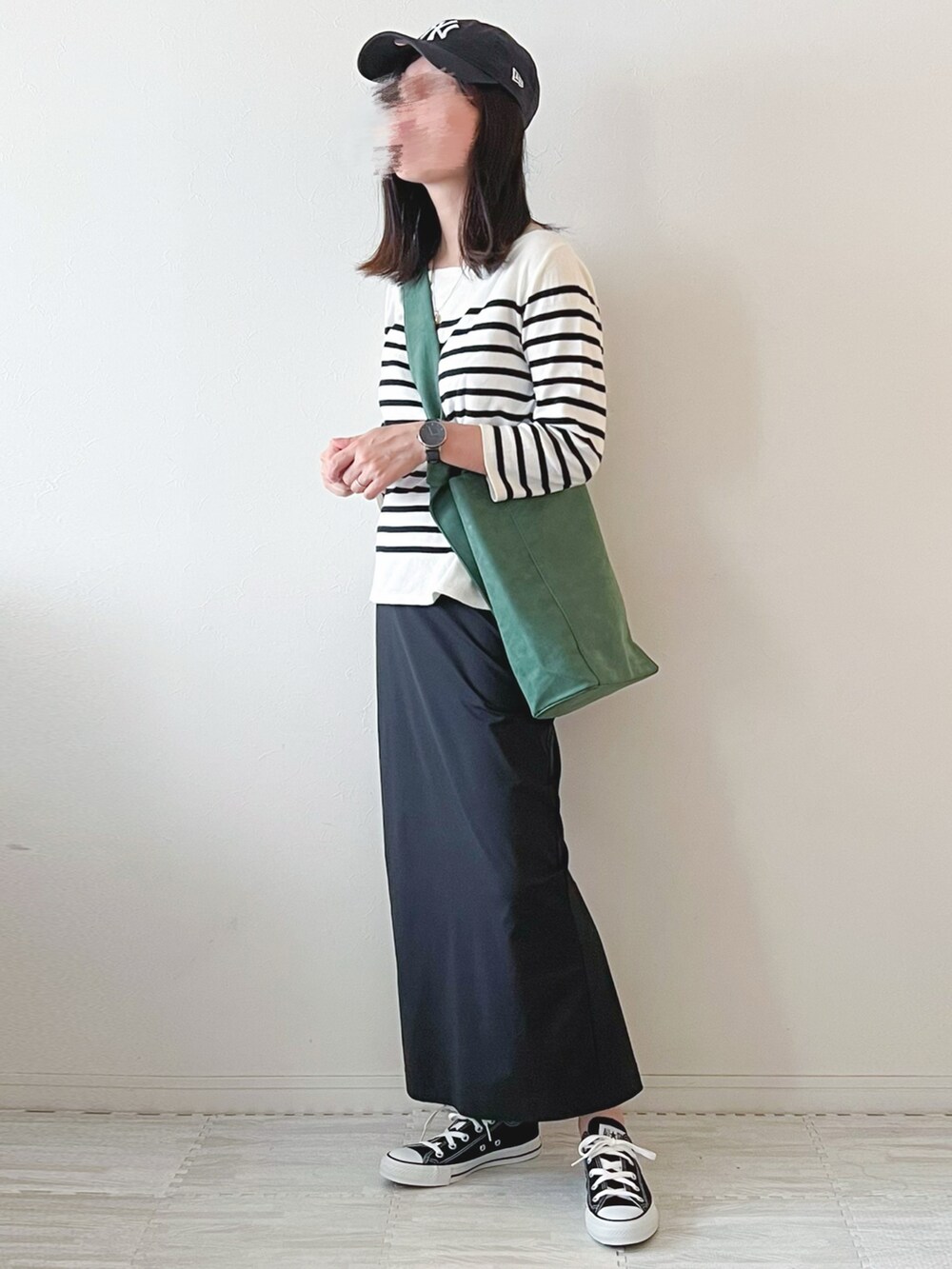 ブラック系のスカート、オレンジ系のショルダーバッグ、ホワイト系のTシャツ/カットソーを着用したレディースの秋コーディネートの2枚目の写真