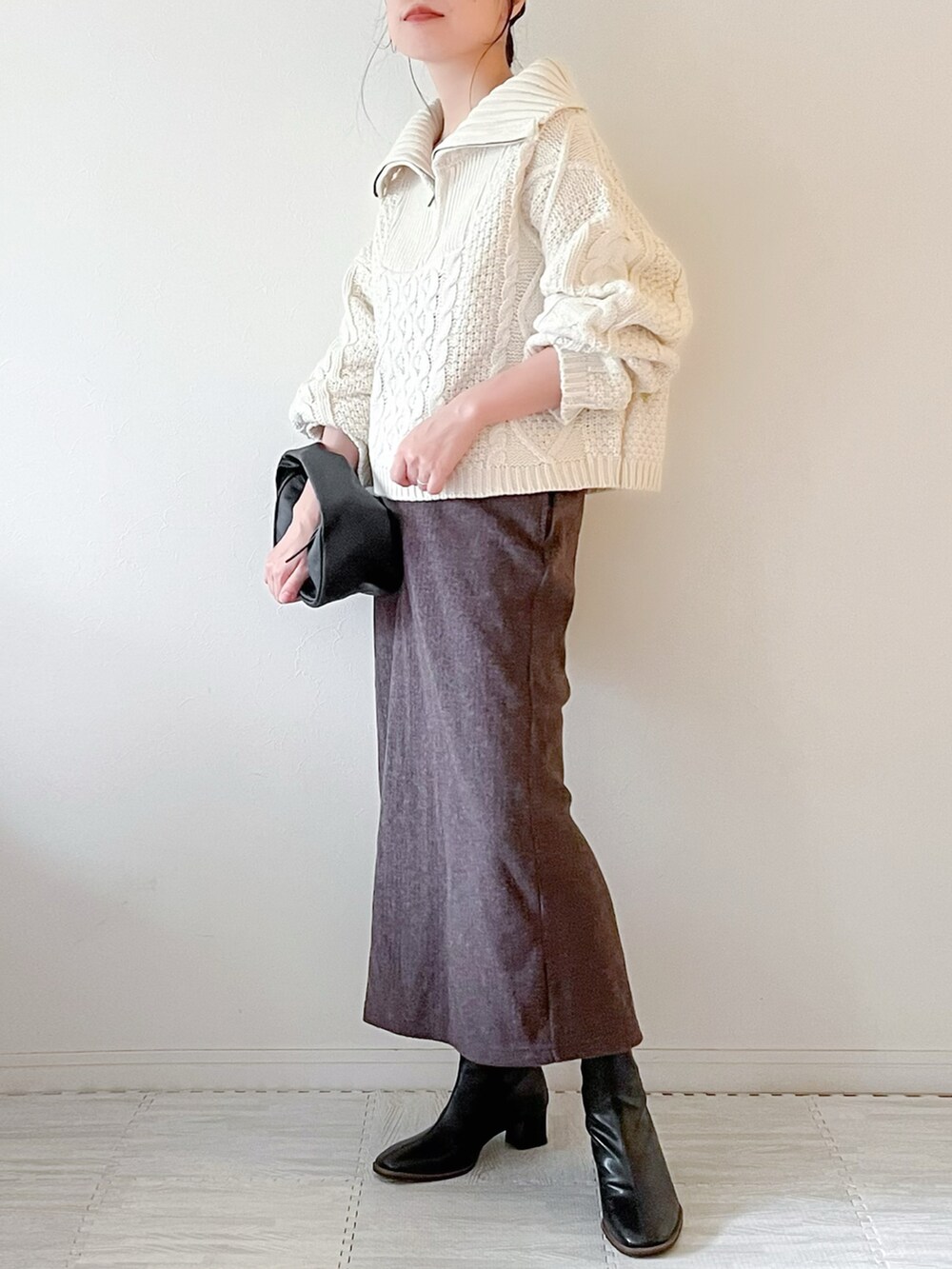 ホワイト系のニット/セーター、ブラック系のショルダーバッグ、ブラウン系のスカートを着用したレディースの秋コーディネートの2枚目の写真