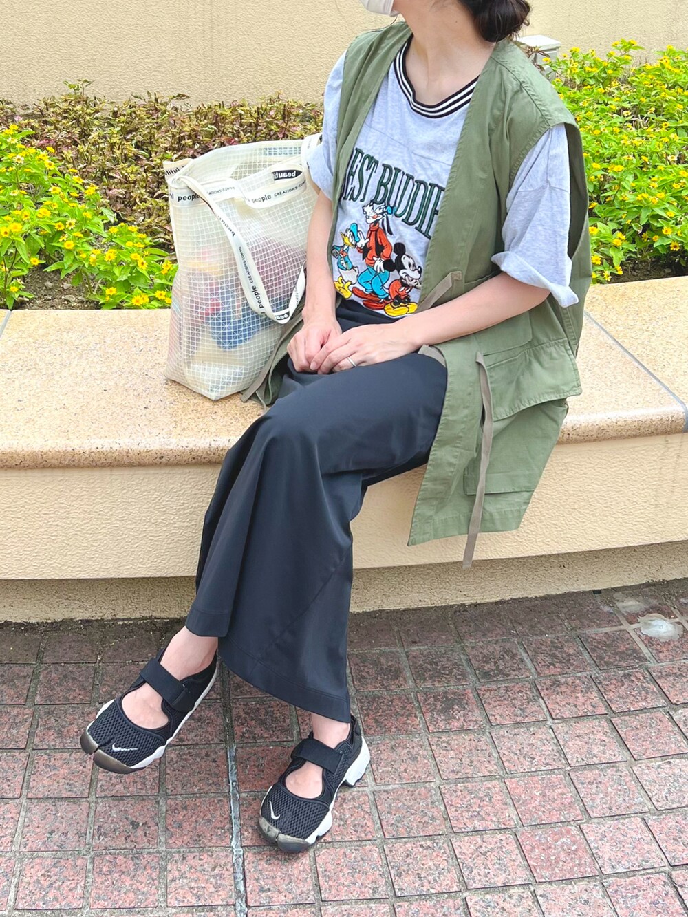 グリーン系のベスト、グレー系のTシャツ/カットソー、ブラック系のスカートを着用したレディースの夏コーディネートの2枚目の写真