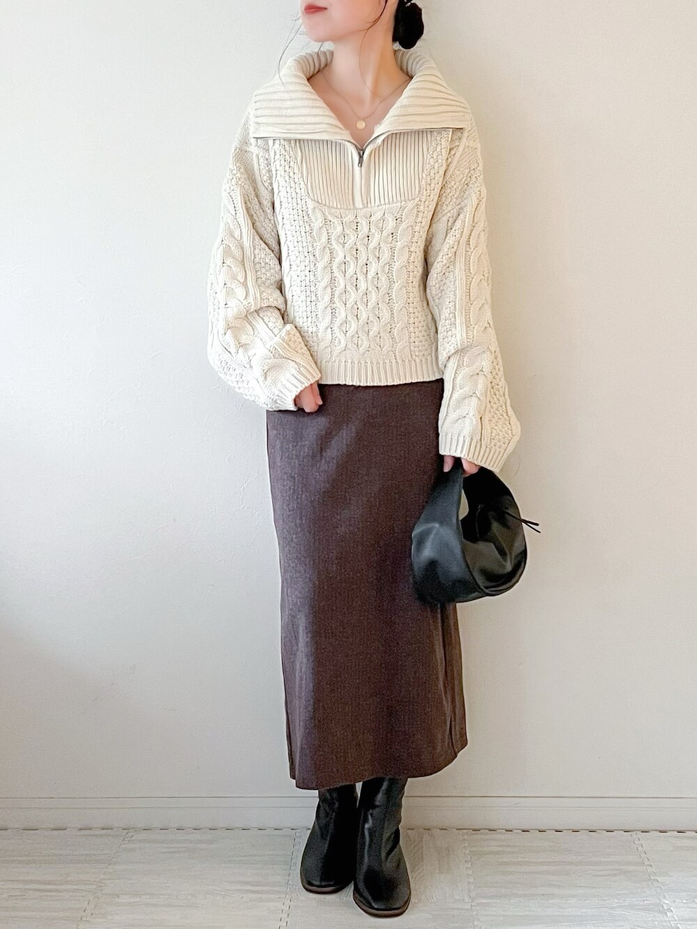 ホワイト系のニット/セーター、ブラック系のショルダーバッグ、ブラウン系のスカートを着用したレディースの秋コーディネートの4枚目の写真