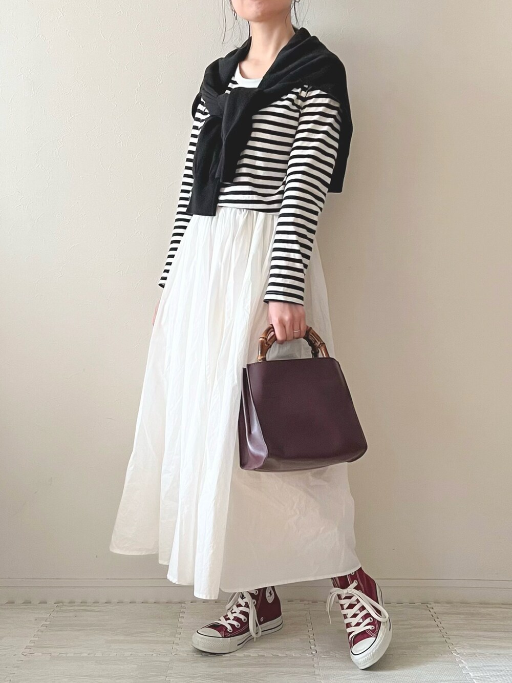 ホワイト系のスカート、パープル系のハンドバッグ、レッド系のスニーカーを着用したレディースの春コーディネートの3枚目の写真