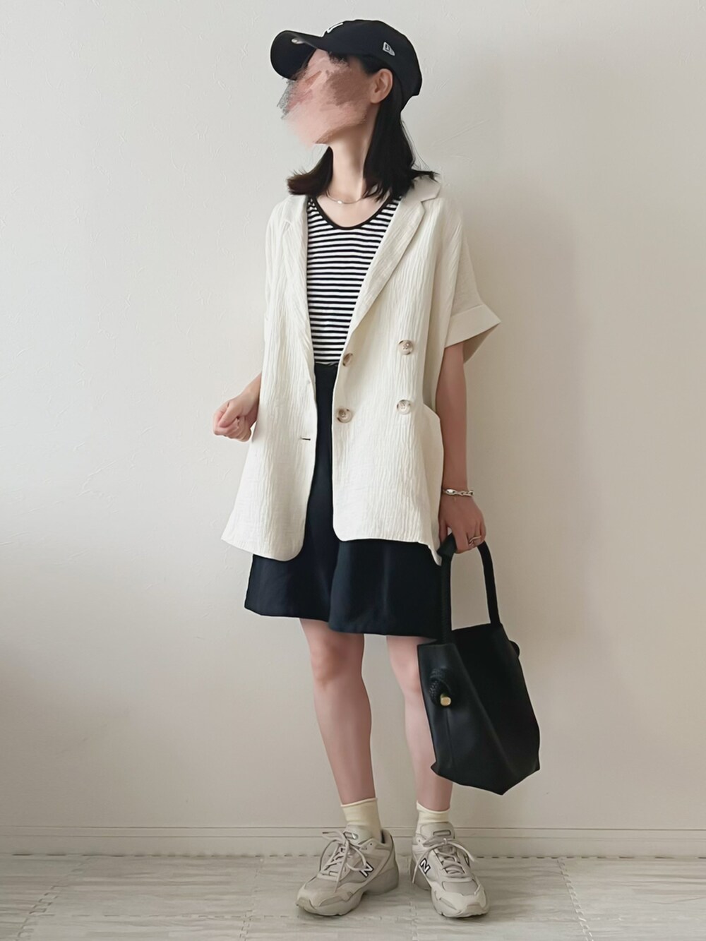 ベージュ系のスニーカー、ブラック系のハンドバッグ、ブラック系のその他パンツを着用したレディースの夏コーディネートの2枚目の写真