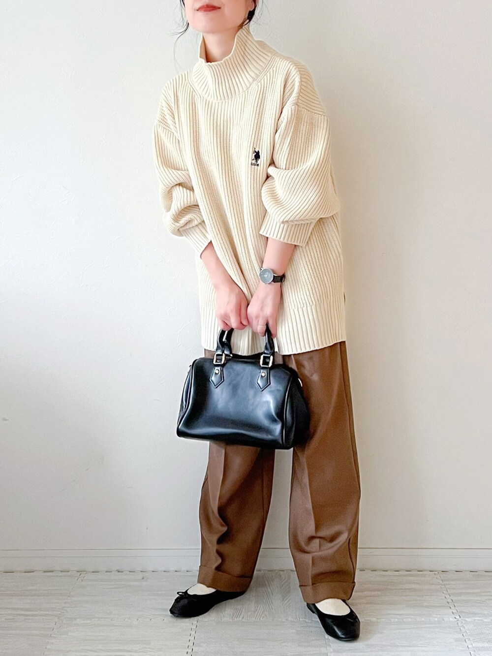 ホワイト系のニット/セーター、ブラック系のボストンバッグ、ブラウン系のパンツを着用したレディースの秋コーディネートの3枚目の写真