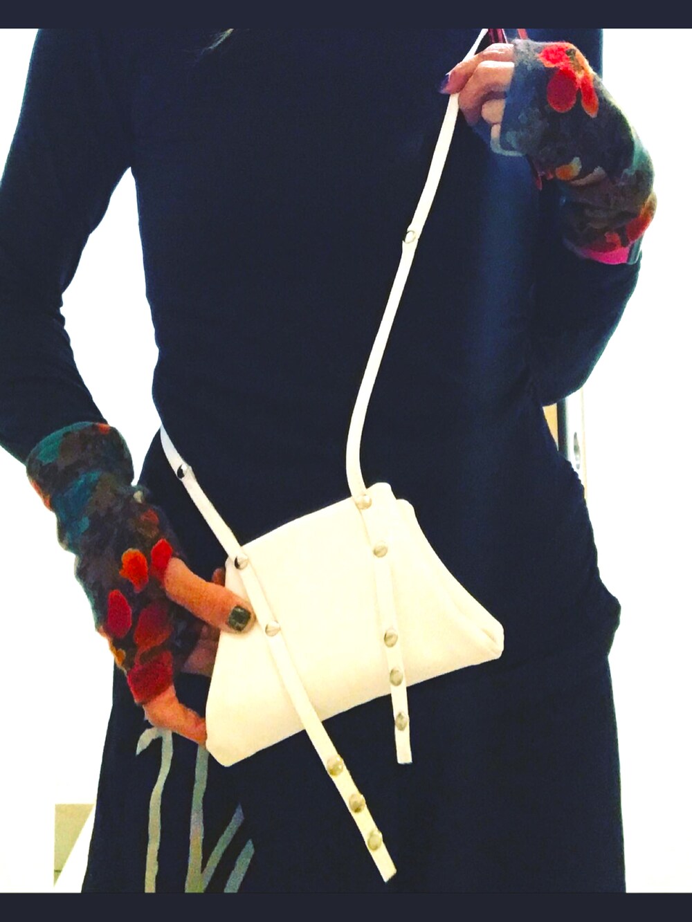 ブラック系のパンツ、ホワイト系のスマホケース/カバーを着用したレディースの秋コーディネートの2枚目の写真