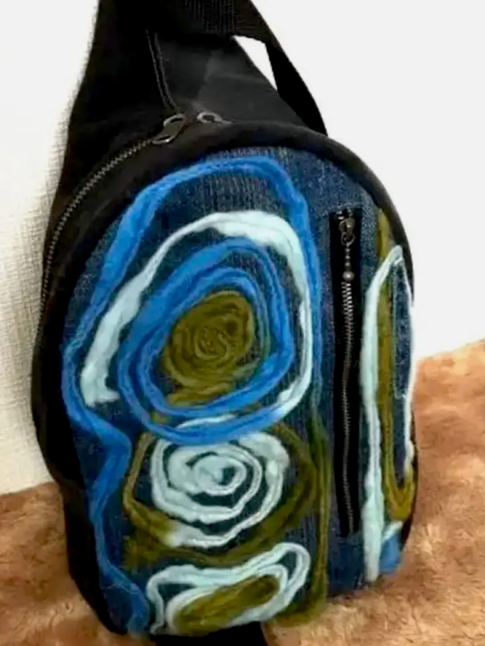 ブラック系のチュニック、グリーン系のカーディガン/ボレロ、ブルー系のボディバッグ/ウエストポーチを着用したレディースの秋コーディネートの3枚目の写真