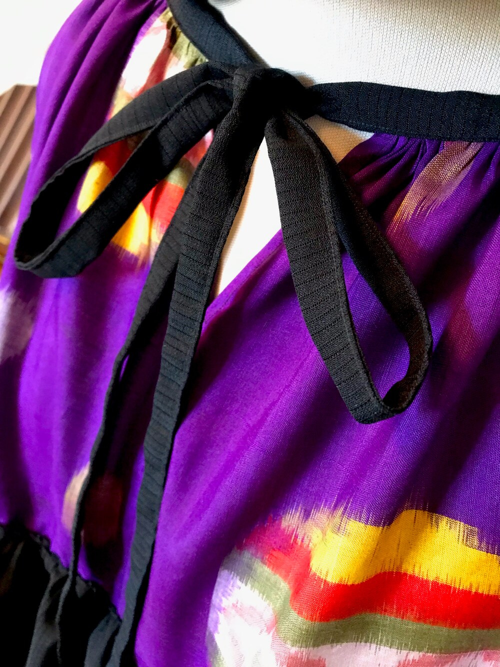 パープル系のチュニックを着用したレディースの春コーディネートの2枚目の写真