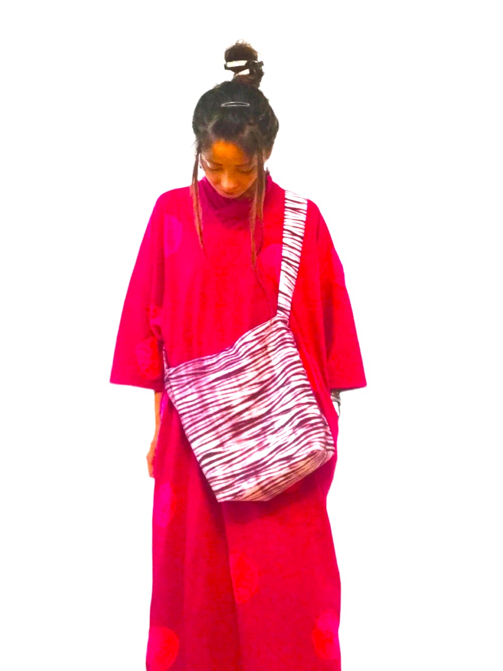 ピンク系のチュニック、ピンク系のショルダーバッグ、ホワイト系のその他パンツを着用したレディースの夏コーディネートの2枚目の写真