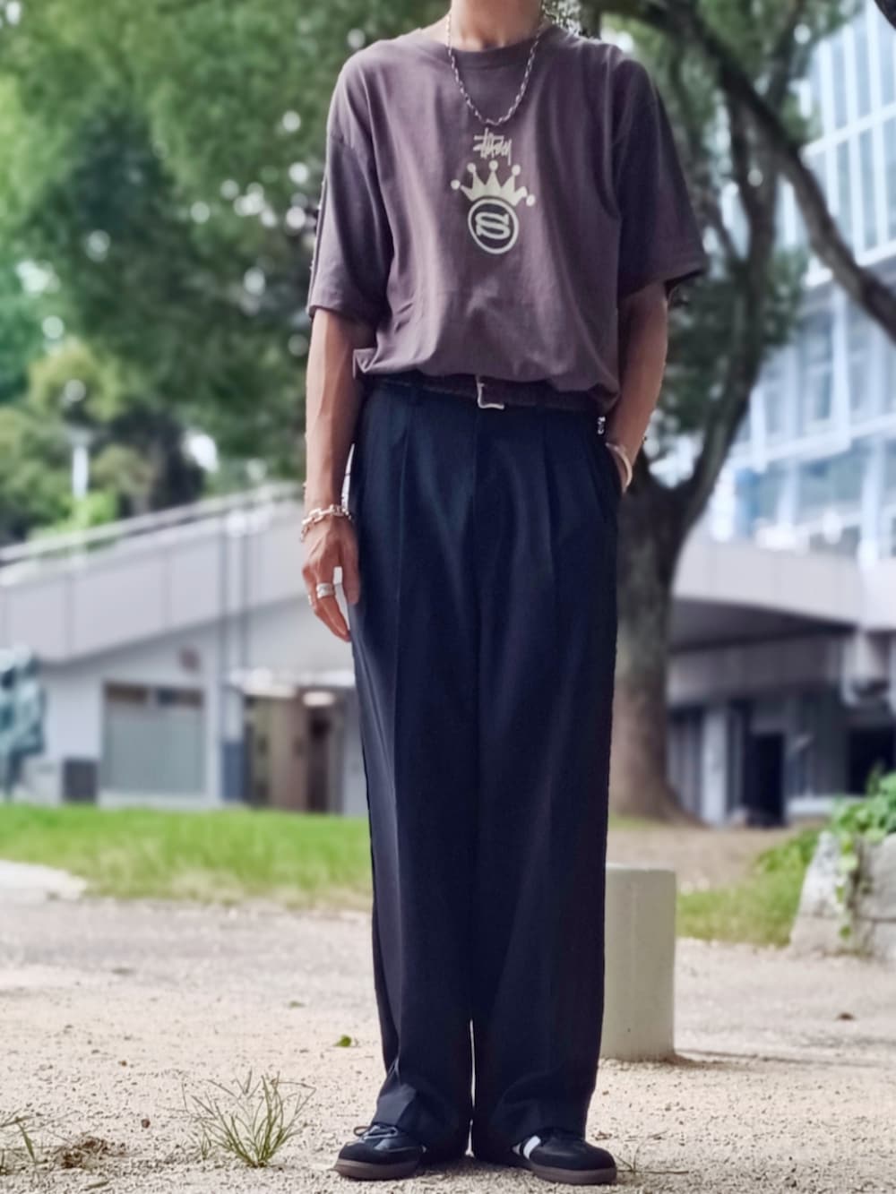 ブラック系のスラックス、ブラック系のTシャツ/カットソー、ブラック系のスニーカーを着用したメンズの夏コーディネートの2枚目の写真