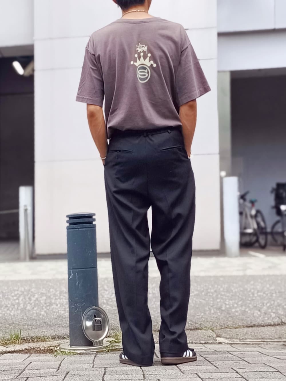 ブラック系のスラックス、ブラック系のTシャツ/カットソー、ブラック系のスニーカーを着用したメンズの夏コーディネートの3枚目の写真
