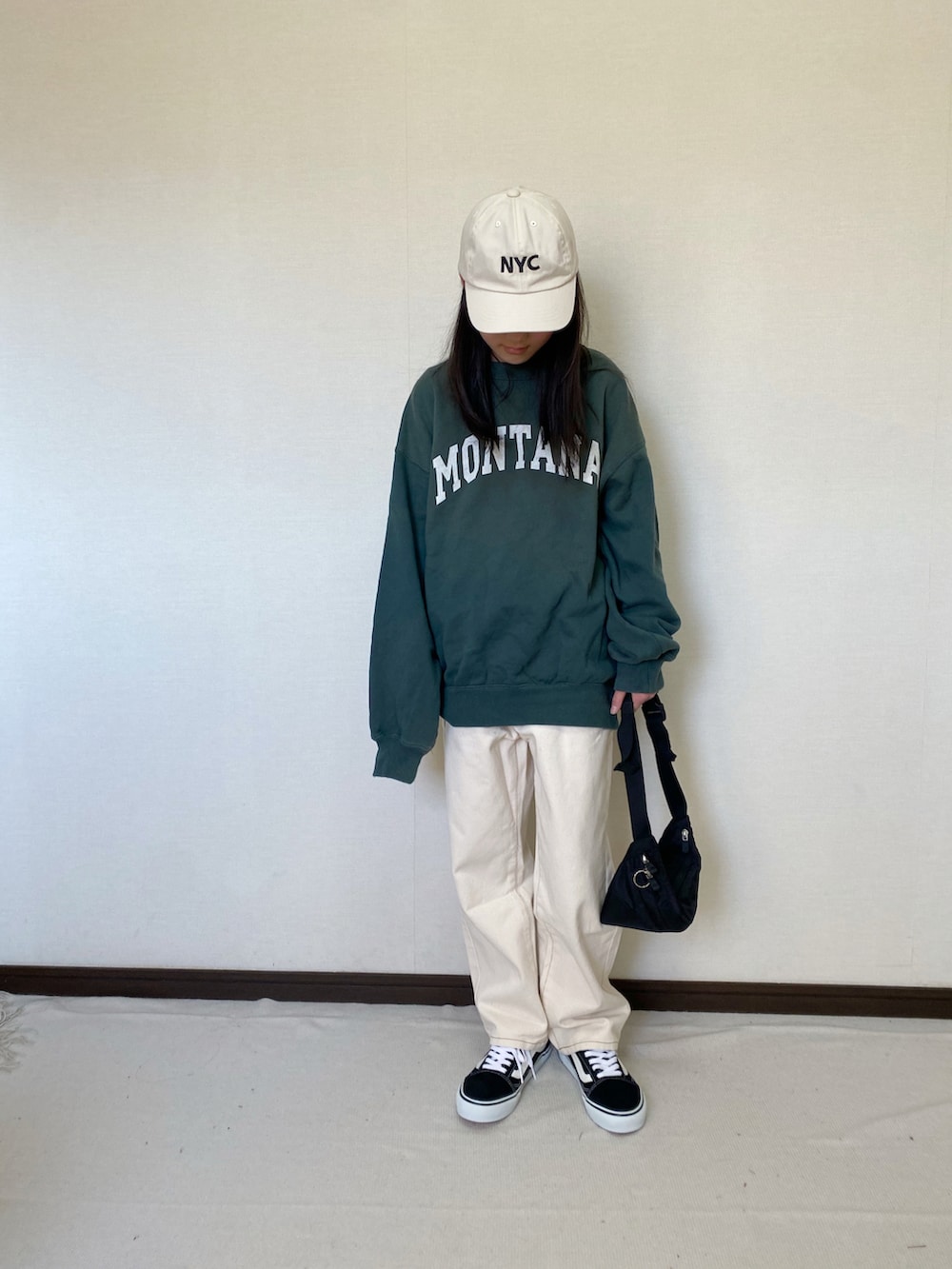 グリーン系のスウェット、ベージュ系のデニムパンツ、ブラック系のショルダーバッグを着用したキッズの春コーディネートの2枚目の写真