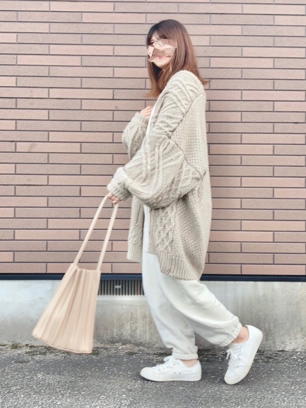 ホワイト系のニット/セーター、ホワイト系のスウェットパンツ、ベージュ系のカーディガン/ボレロを着用したレディースの冬コーディネートの2枚目の写真