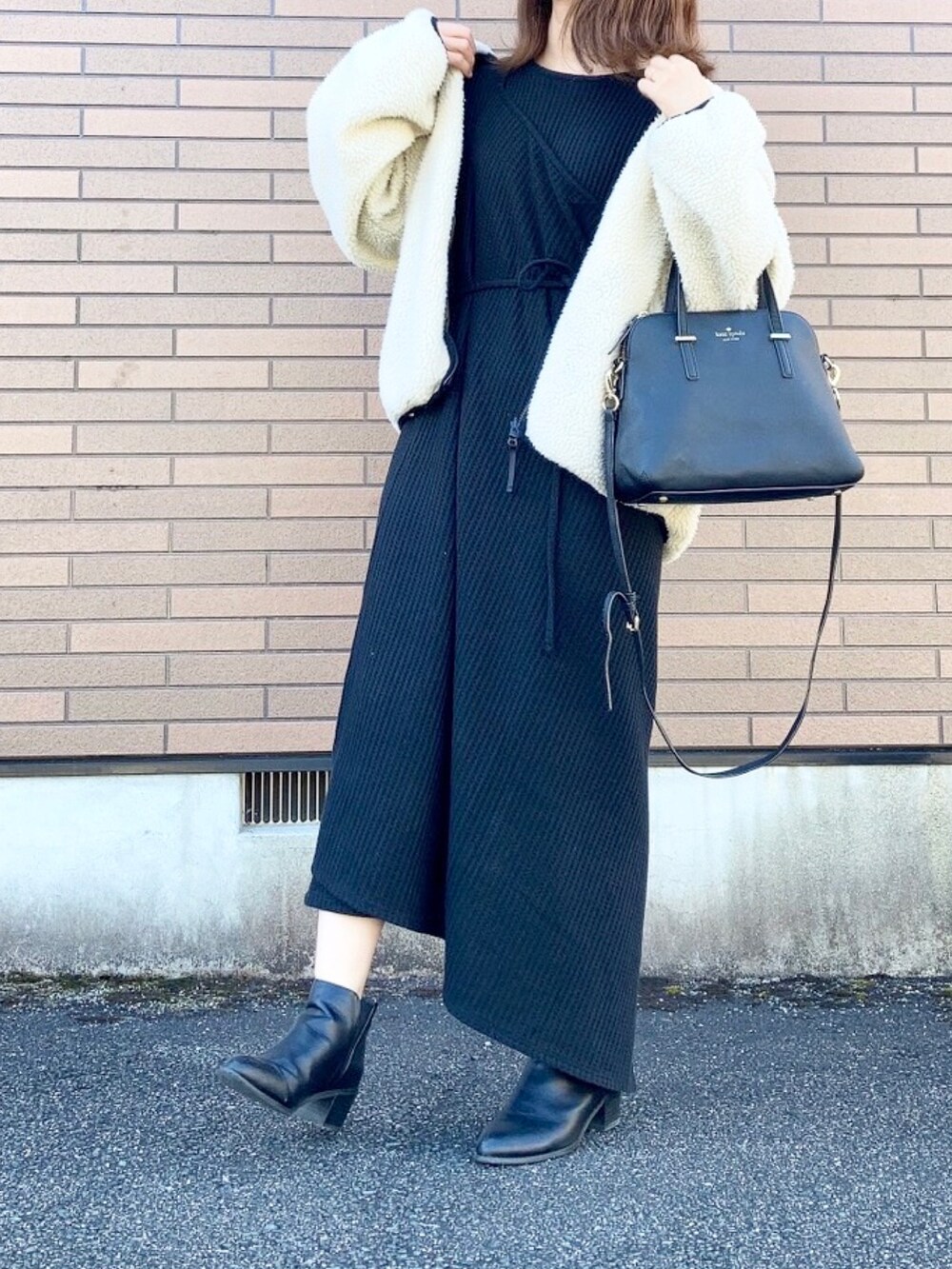 ブラック系のブルゾン、ブラック系のワンピース、ブラック系のショルダーバッグを着用したレディースの秋コーディネートの3枚目の写真