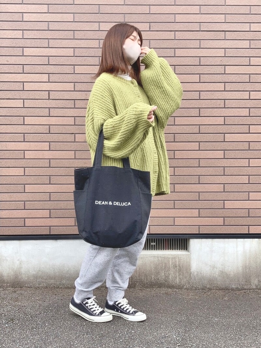 グリーン系のカーディガン/ボレロ、ブラック系のトートバッグ、ブラック系のスニーカーを着用したレディースの冬コーディネートの2枚目の写真