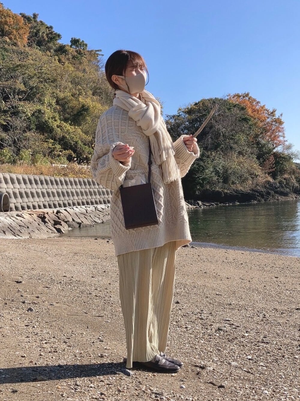 ホワイト系のニット/セーター、ブラウン系のローファー、ブラウン系のショルダーバッグを着用したレディースの冬コーディネートの2枚目の写真