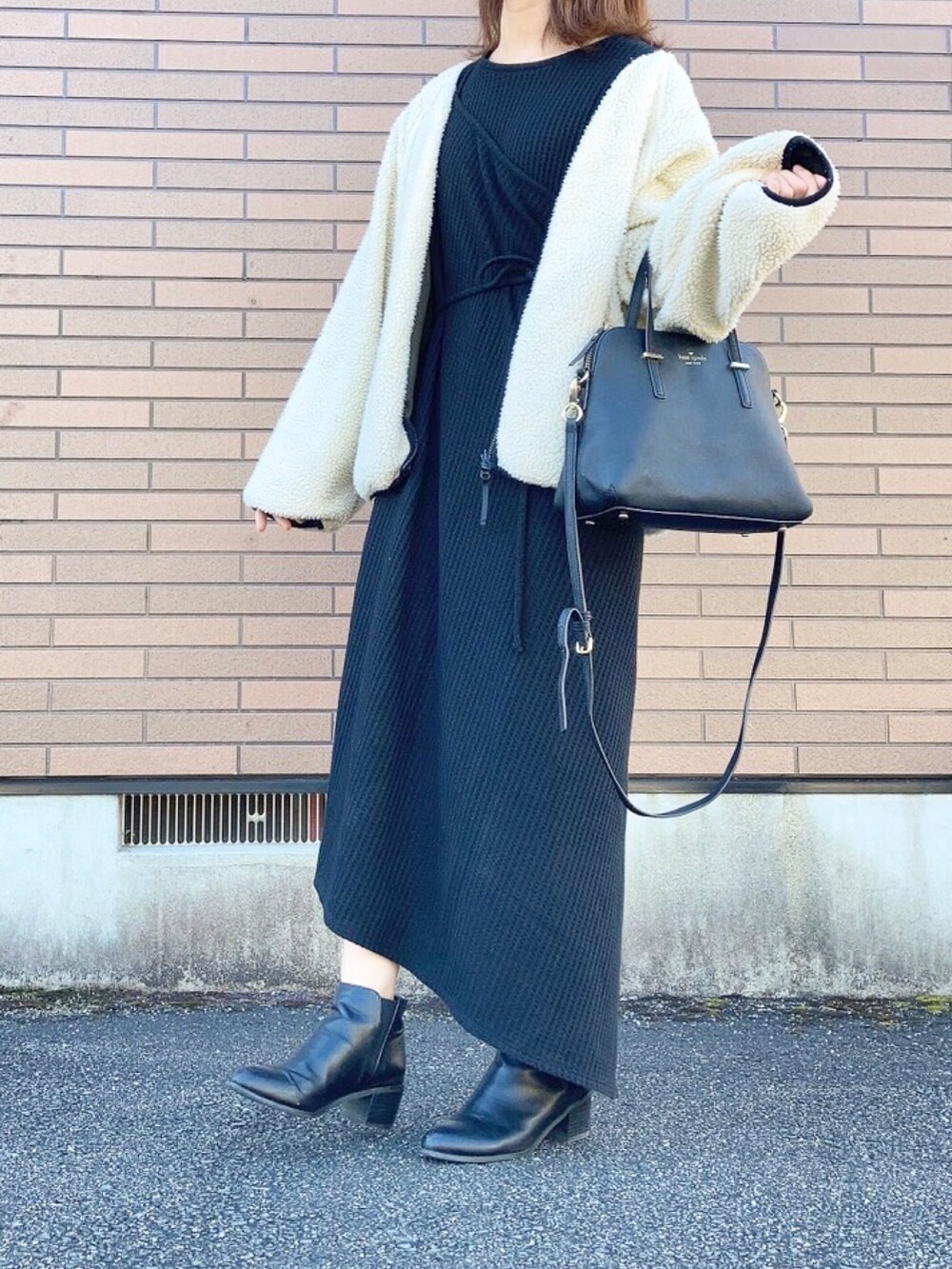 ブラック系のブルゾン、ブラック系のワンピース、ブラック系のショルダーバッグを着用したレディースの秋コーディネートの2枚目の写真