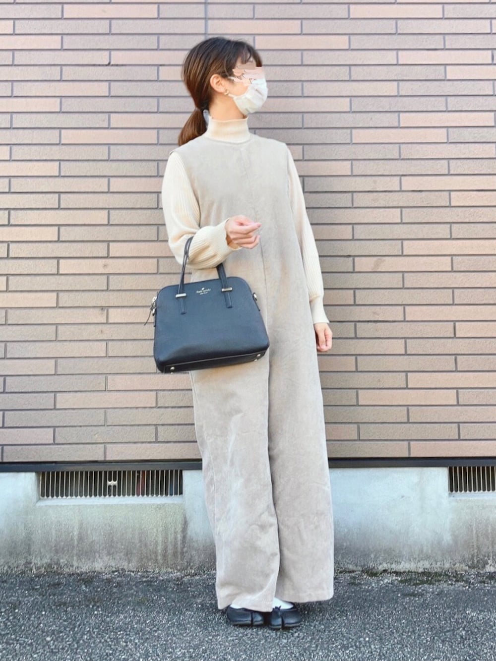 ホワイト系のニット/セーター、ホワイト系のブルゾン、ベージュ系のサロペット/オーバーオールを着用したレディースの冬コーディネートの2枚目の写真