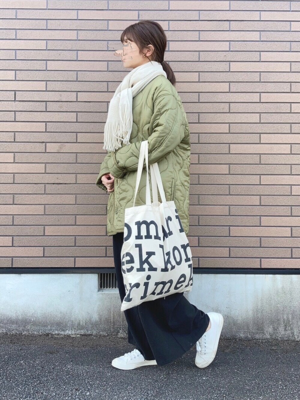 グリーン系のジャケット/アウター、ホワイト系のトートバッグ、ホワイト系のスニーカーを着用したレディースの冬コーディネートの3枚目の写真