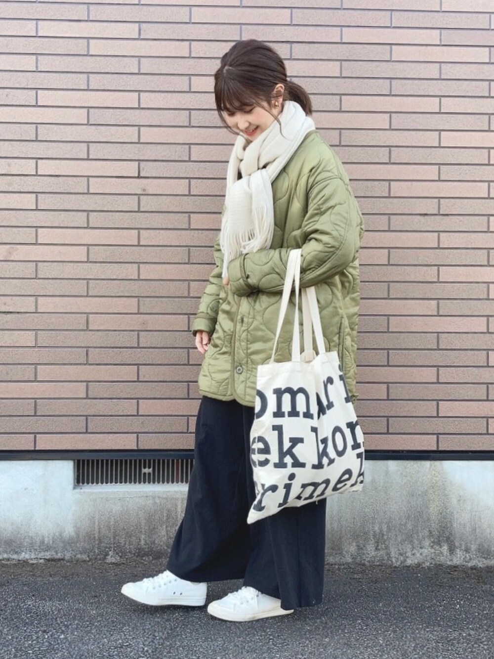 グリーン系のジャケット/アウター、ホワイト系のトートバッグ、ホワイト系のスニーカーを着用したレディースの冬コーディネートの2枚目の写真