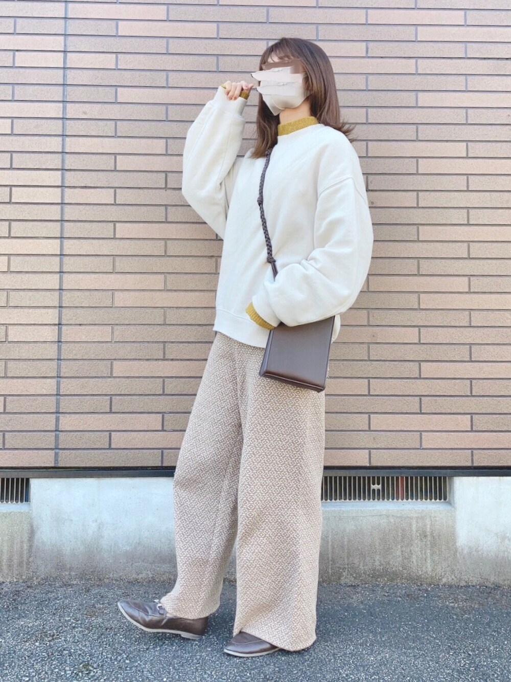 ベージュ系のスウェット、ブラウン系のショルダーバッグ、イエロー系のニット/セーターを着用したレディースの冬コーディネートの2枚目の写真