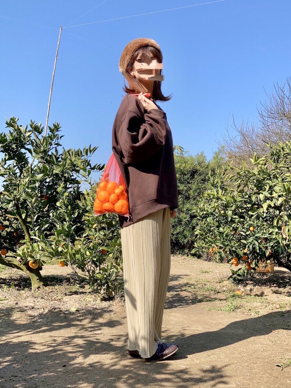 ブラウン系のスウェット、イエロー系のその他パンツ、ブラウン系のローファーを着用したレディースの秋コーディネートの3枚目の写真