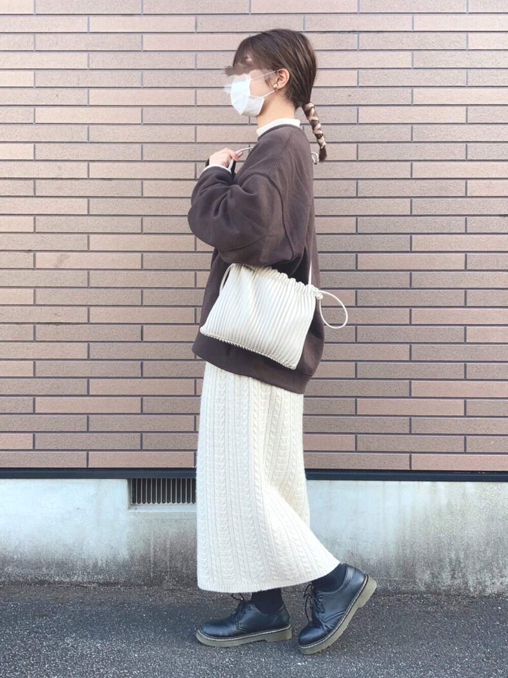 ブラウン系のスウェット、ホワイト系のショルダーバッグ、ホワイト系のスカートを着用したレディースの冬コーディネートの2枚目の写真