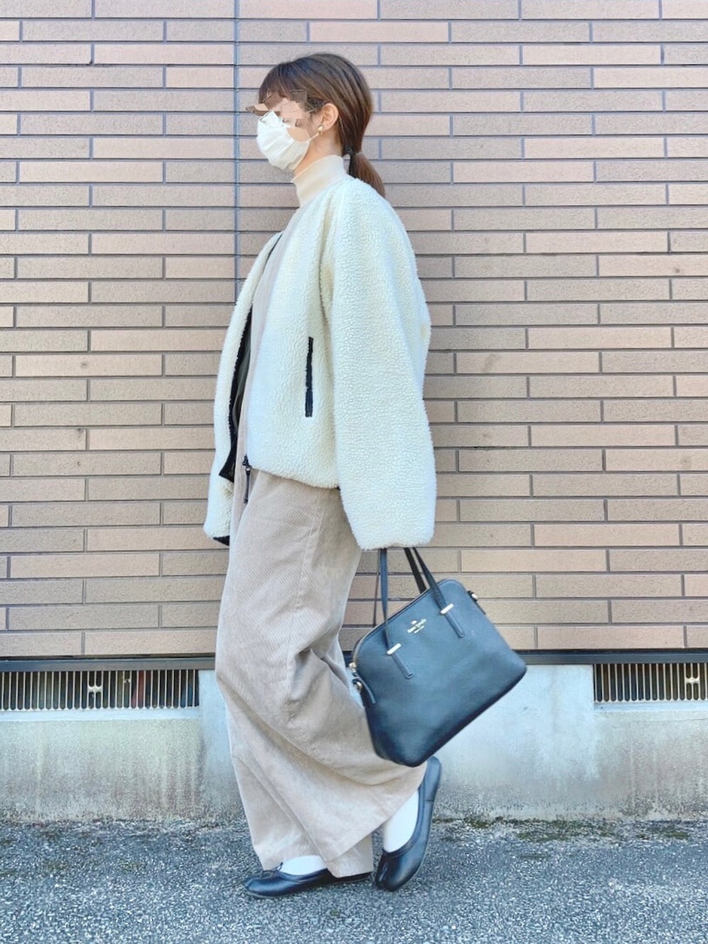 ホワイト系のニット/セーター、ホワイト系のブルゾン、ベージュ系のサロペット/オーバーオールを着用したレディースの冬コーディネートの3枚目の写真