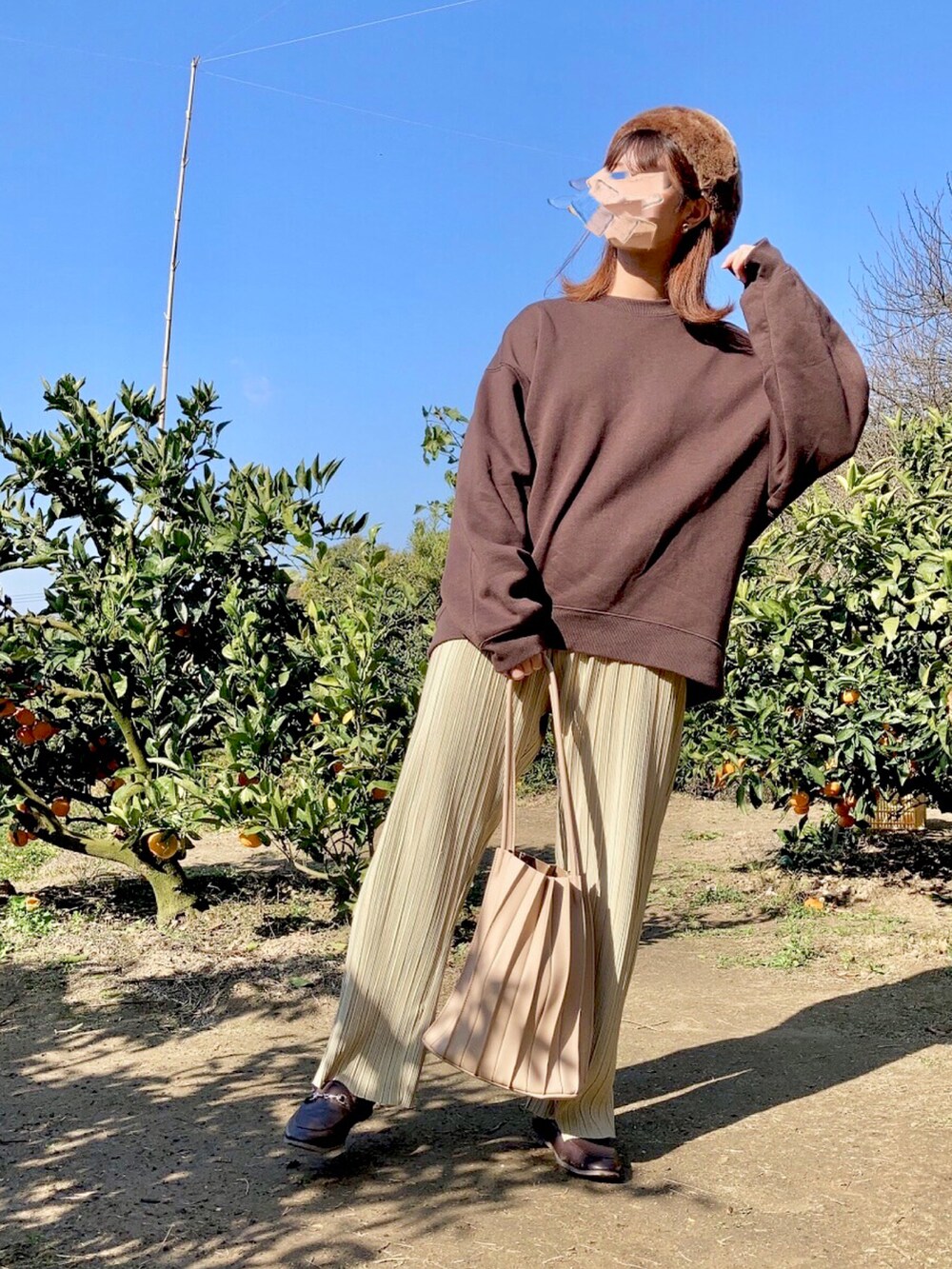 ブラウン系のスウェット、イエロー系のその他パンツ、ブラウン系のローファーを着用したレディースの秋コーディネートの2枚目の写真