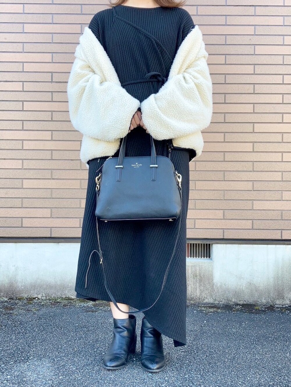 ブラック系のブルゾン、ブラック系のワンピース、ブラック系のショルダーバッグを着用したレディースの秋コーディネートの4枚目の写真