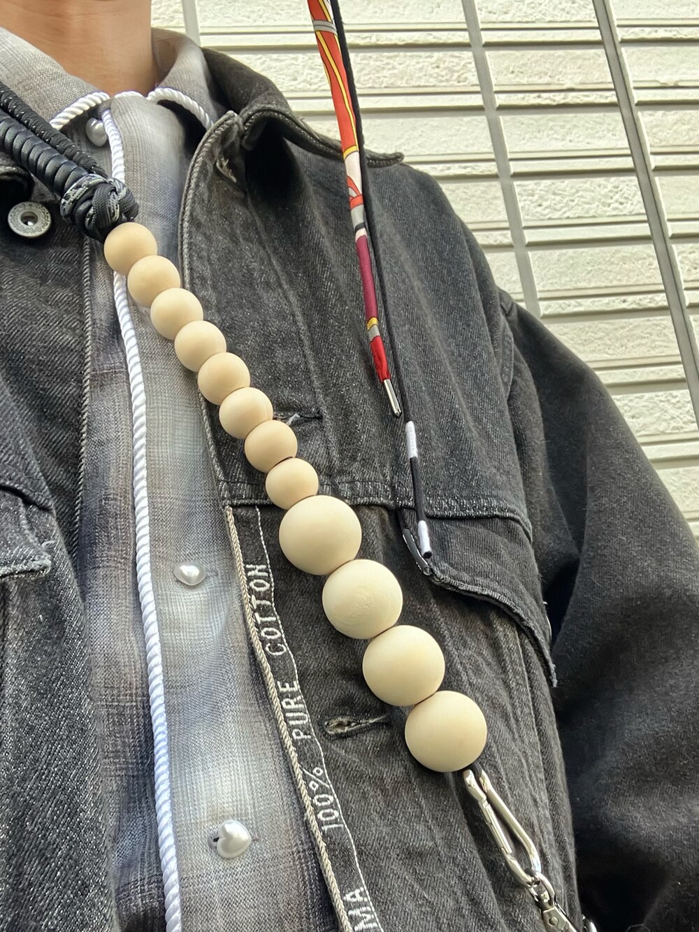 ブラック系のデニムジャケット、ブラック系のデニムパンツ、ホワイト系のスニーカーを着用したメンズの春コーディネートの4枚目の写真