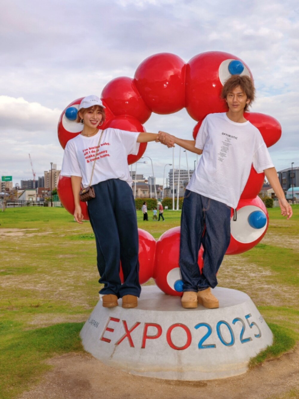 ホワイト系のTシャツ/カットソー、ブラウン系のショルダーバッグ、ブルー系のスウェットパンツを着用したレディースの秋コーディネートの4枚目の写真